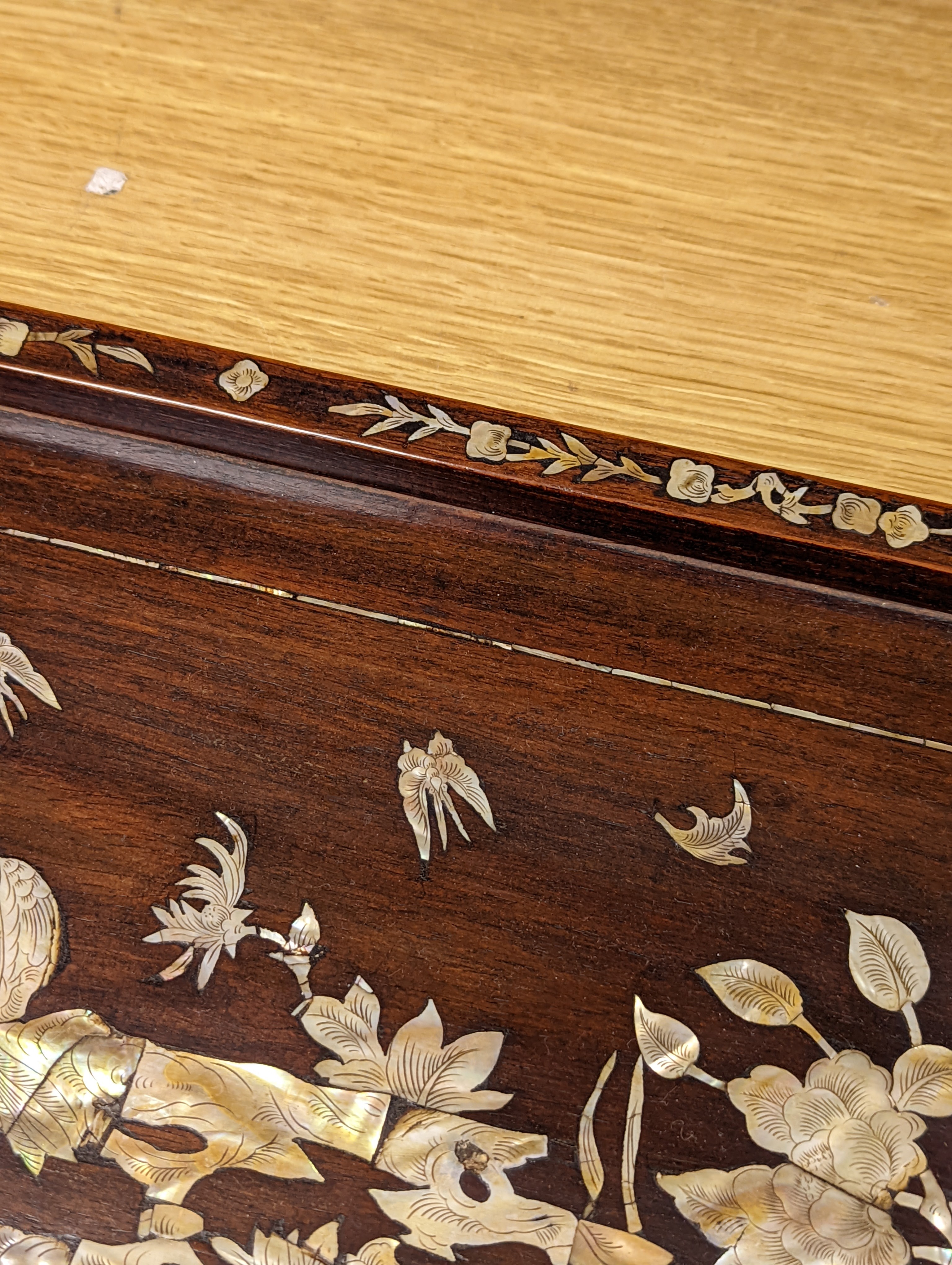 Two Chinese mother of pearl inlaid hongmu trays, the rectangular example with birds and insects amid flowers and the smaller oval example with a pavilion in a landscape within floral sprays 55x34cm